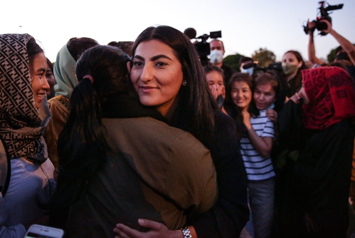 The captain of Afghanistan national women football team, Farkhunda Muhtaj (C), welcomes teammates in Portugal at Belem Tower in Lisbon on September 29, 2021.
