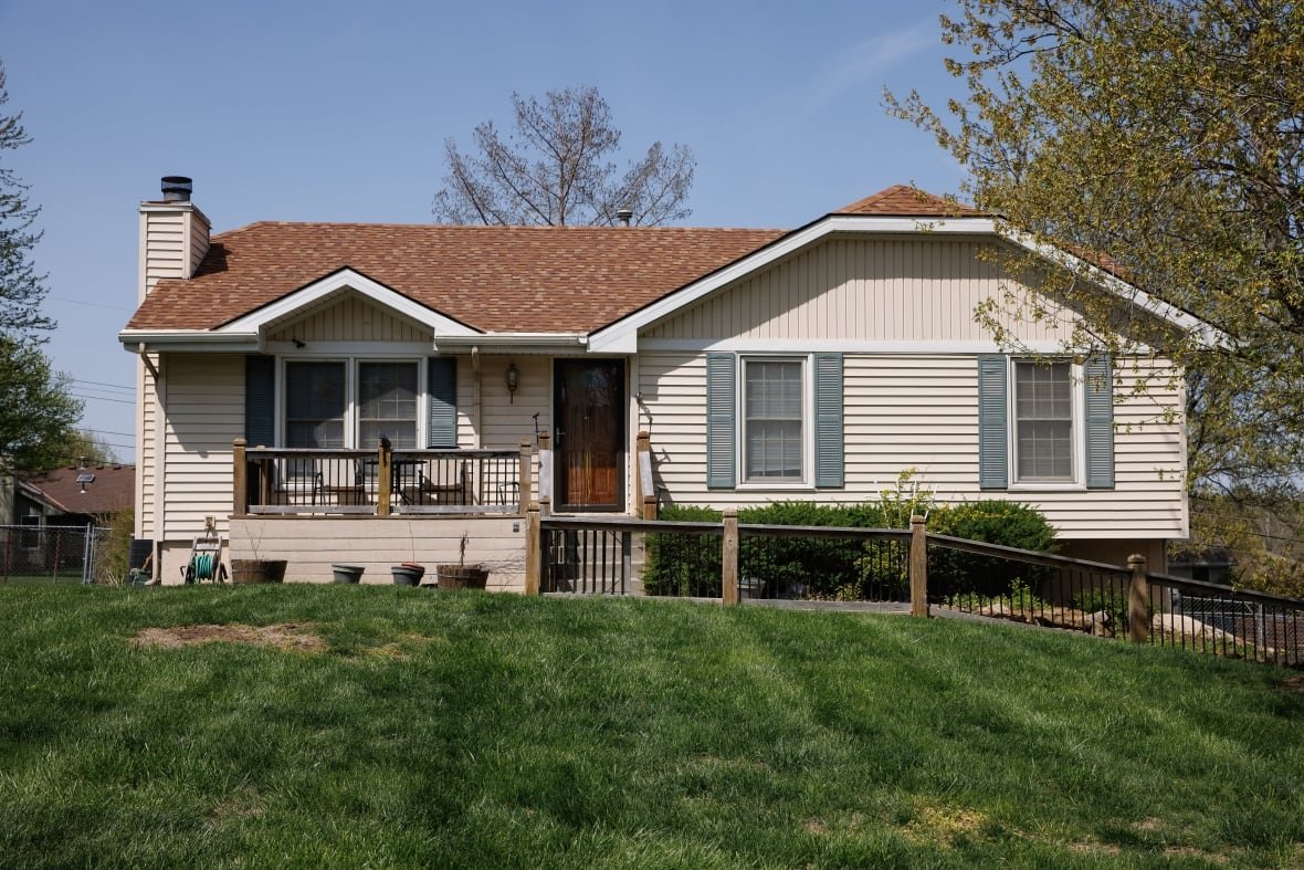 A one-story home is shown with a green lawn from the street.