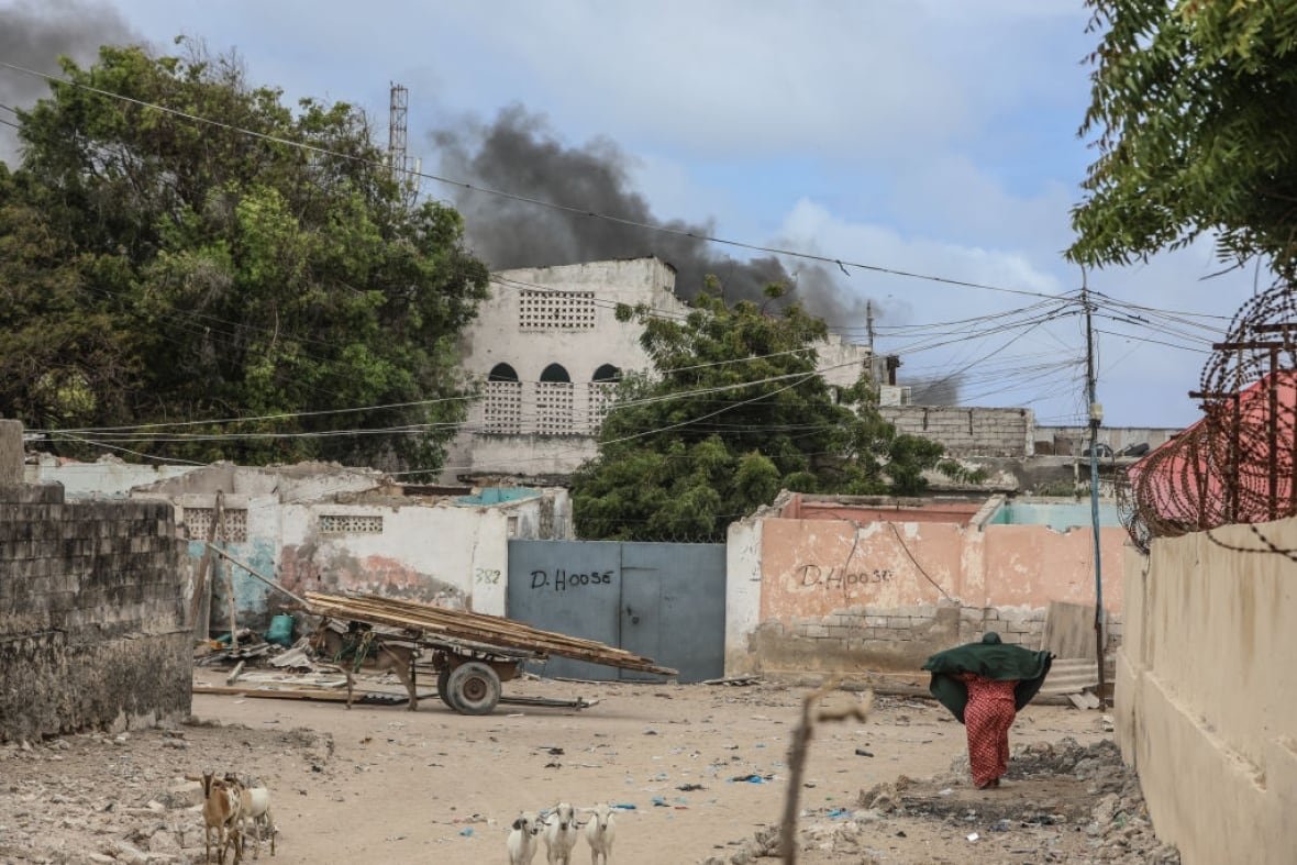 2164593677 Smoke rises from a building at a beach in Somalia.