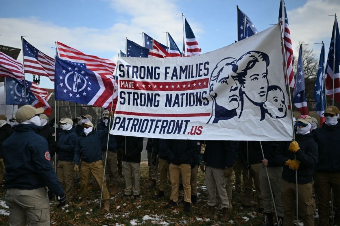 2195073977 Members of Patriot Front rally on the National Mall in Washington, DC, during the annual "March for Life." There is a flag for Patriot Front that says: Strong Families, Strong Nations. As well as several U.S. flags.