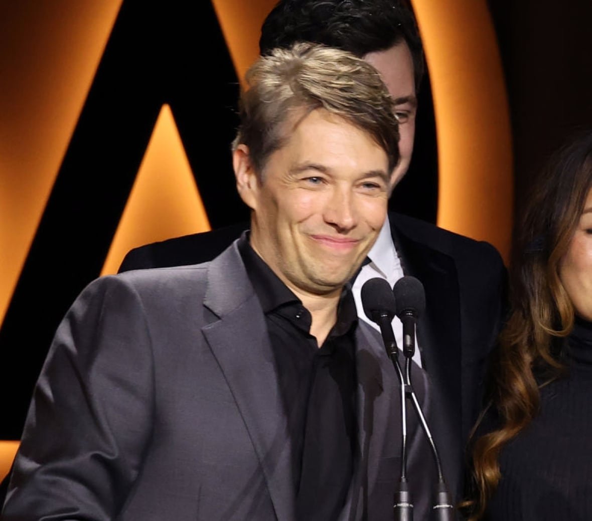 2198478022 A man smiles at the podium.