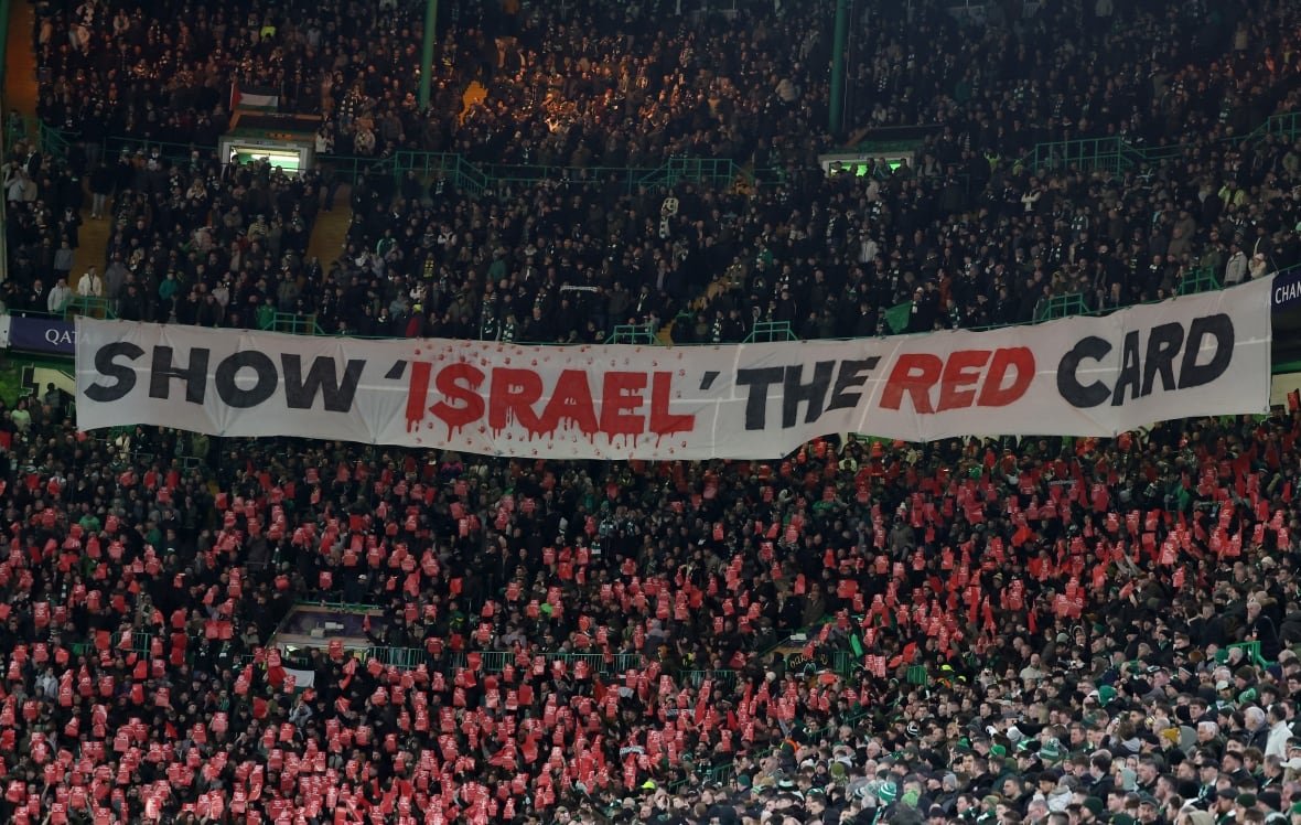 2199184919-1 Fans hold a white banner reading "Show Israel the red card."