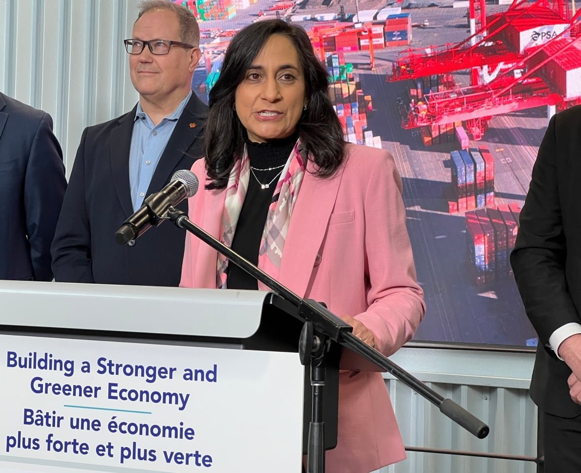 A woman speaks behind a podium as others look on.