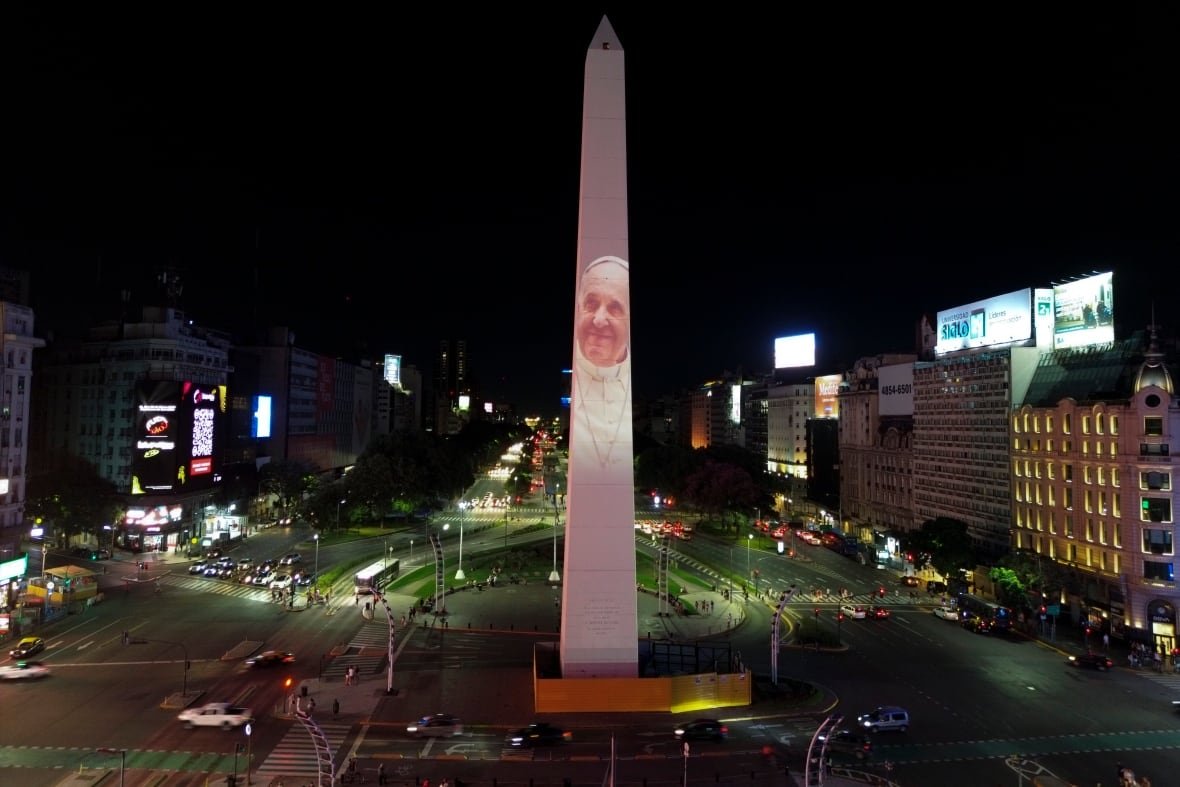 argentina-pope A person's portrait is projected on a large obelisk in the middle of a city street.