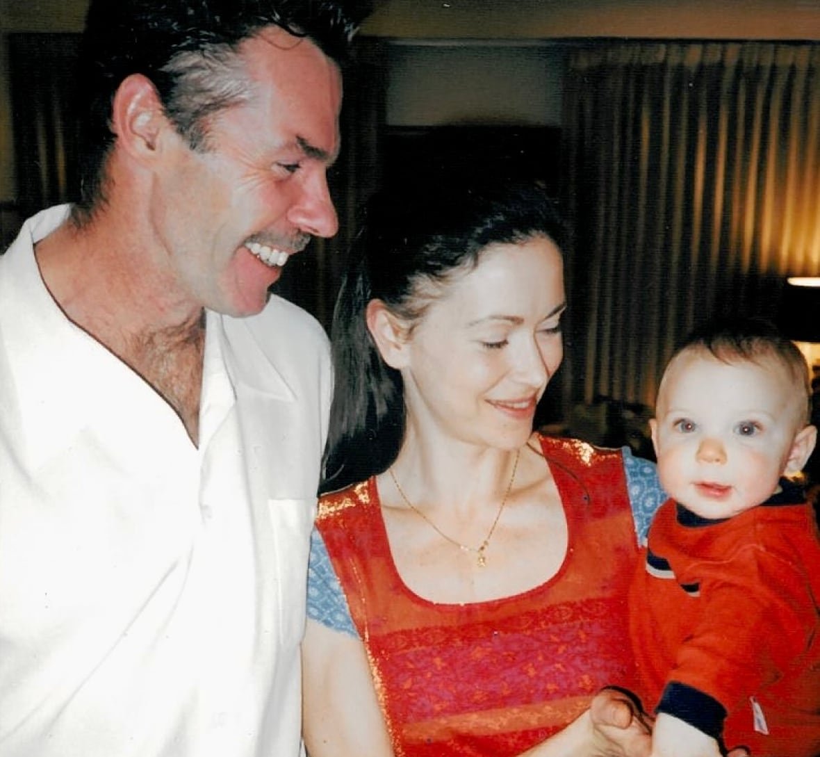 barry-flynn-1 A man and woman are smiling as they hold a baby.