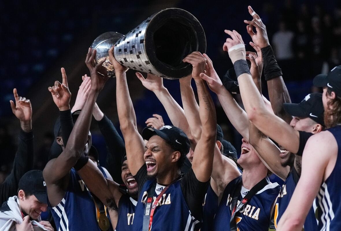 bko-u-sports-men-championship-20250316 A men's basketball team celebrates by raising the trophy.