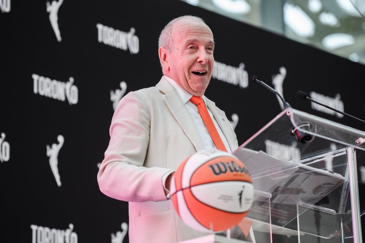 bkw-wnba-toronto-20240523 A man speaks at a podium.