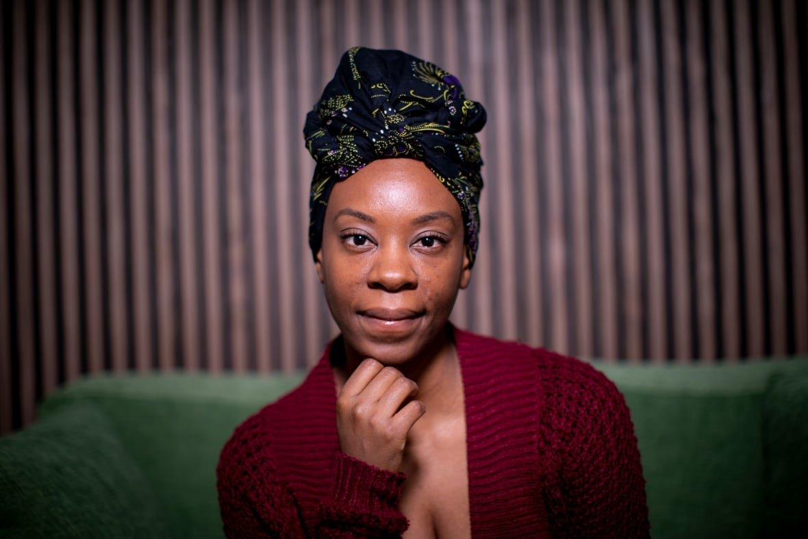 A Black woman has her hair wrapped.