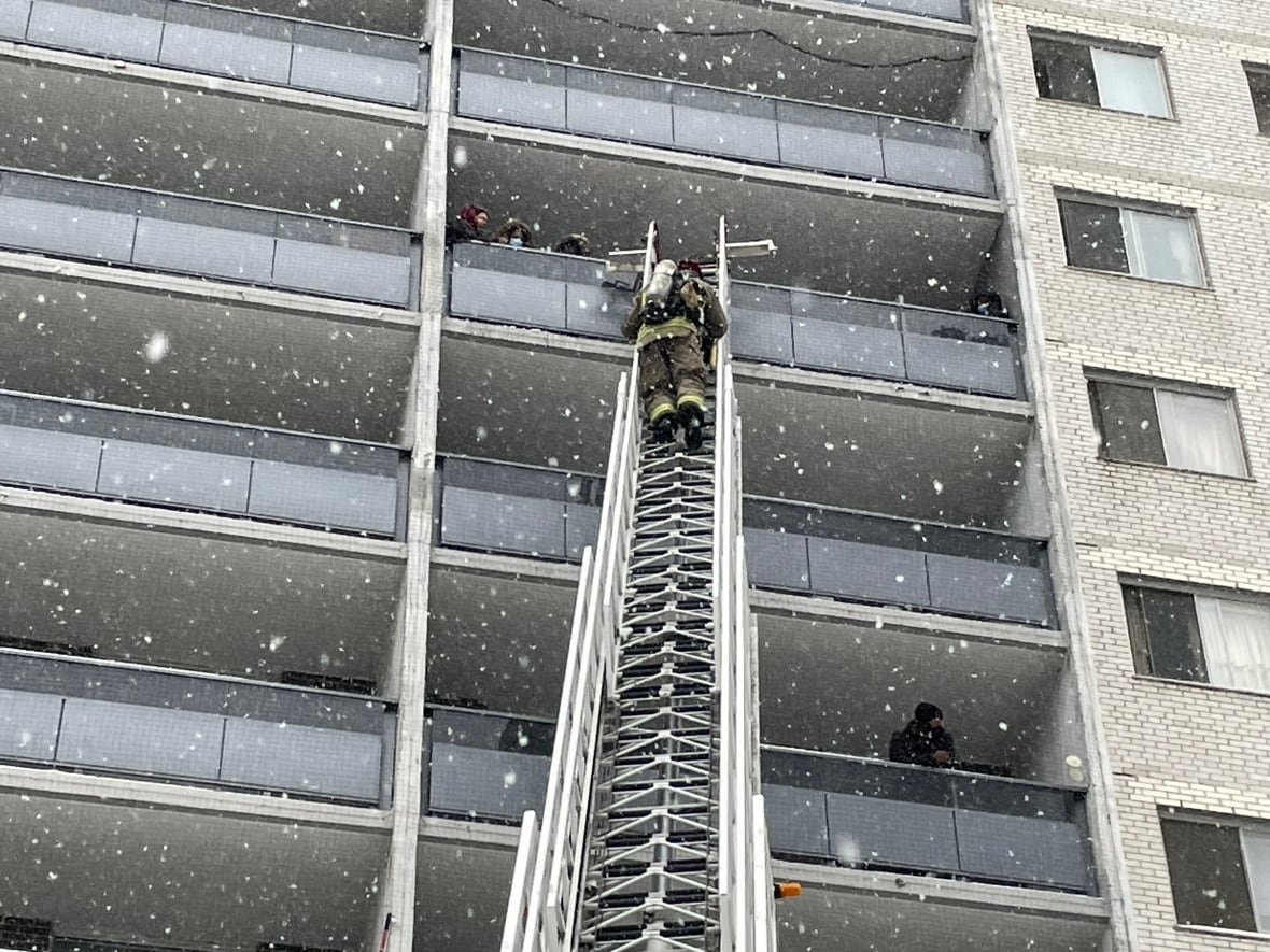 bleeker-street-apartment-fire-feb-15-2025 A firefighter on an aerial ladder along the side of a high-rise building.