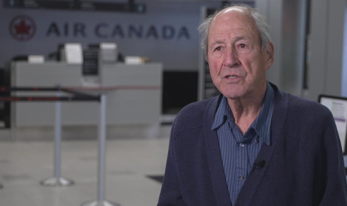 Man speak to reporter with Air Canada sign behind him