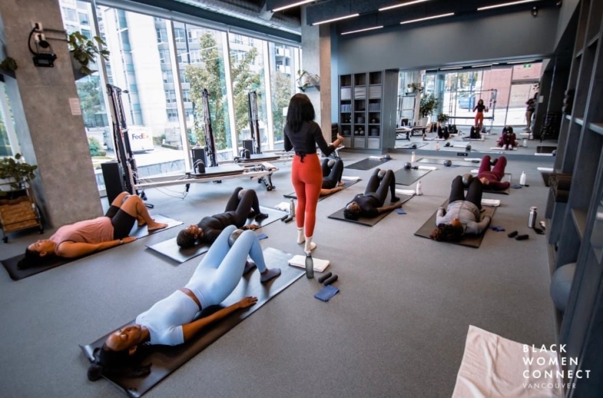 Women lie on yoga mats at a yoga class.