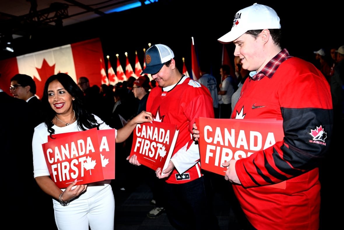 conservatives-rally-20250215-1 A supporter gets a sign before Conservative Leader Pierre Poilievre's Canada First rally in Ottawa, on Saturday, Feb. 15, 2025.