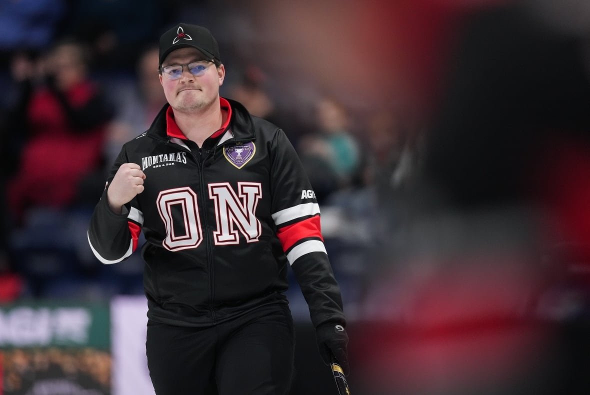 cur-men-brier-20250301 A curling athlete pumps their fist in the air, celebrating a victorious moment on the ice.