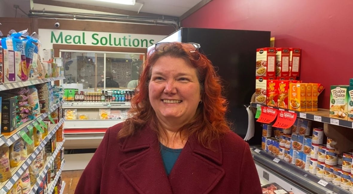 A woman standing in a grocery store aisle