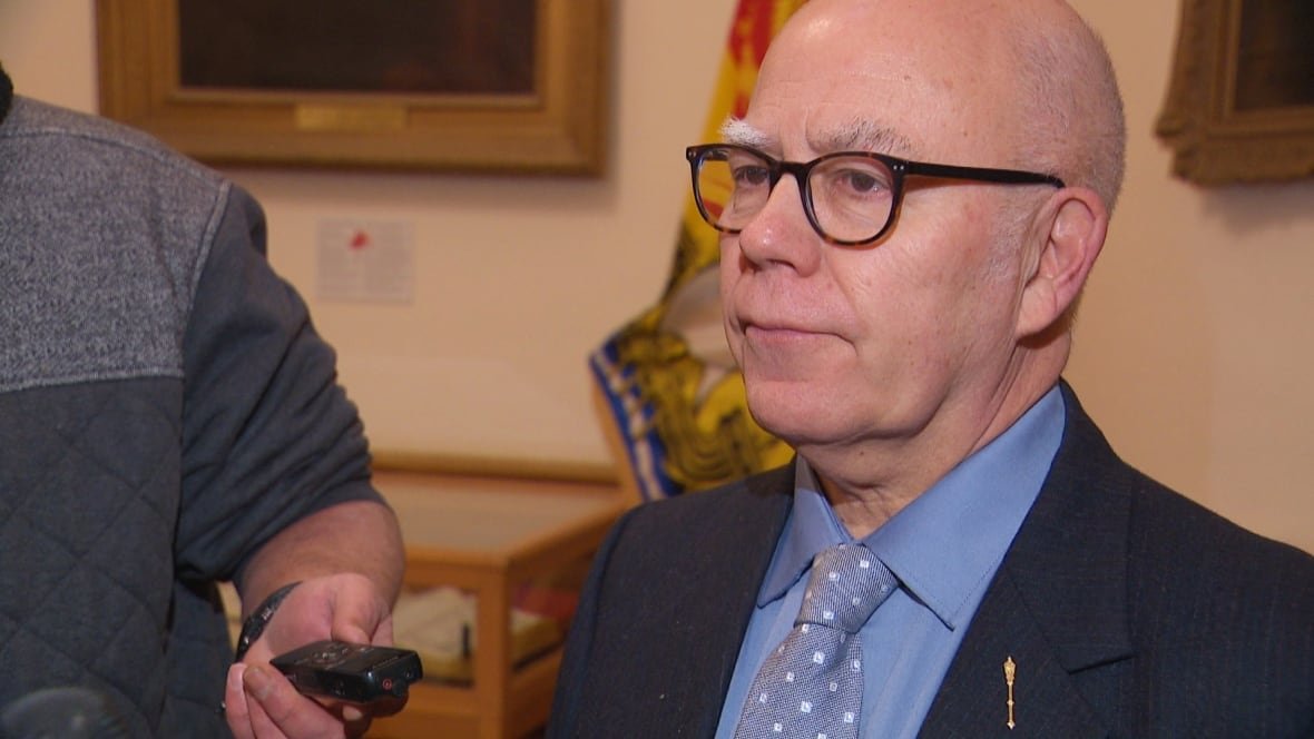 david-coon A bald man with black glasses, wearing a suit jacket and matching blue shirt and tie.