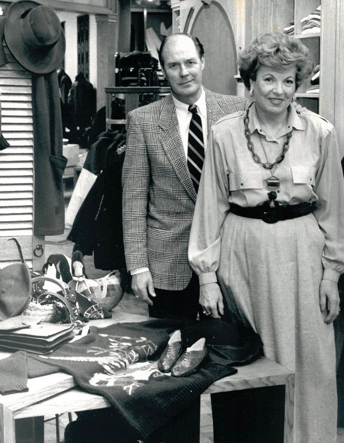 elwood-and-joan-flynn A man and woman stand in a clothing store in an old black and white photo.
