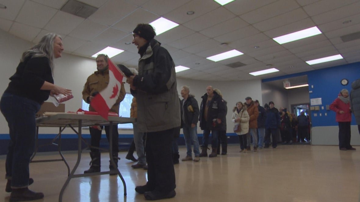 flag-giveaway A group of people lienup at an event in Winnipeg.