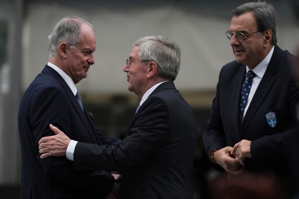 greece-olympics-ioc-election-2 Three men greet each other.
