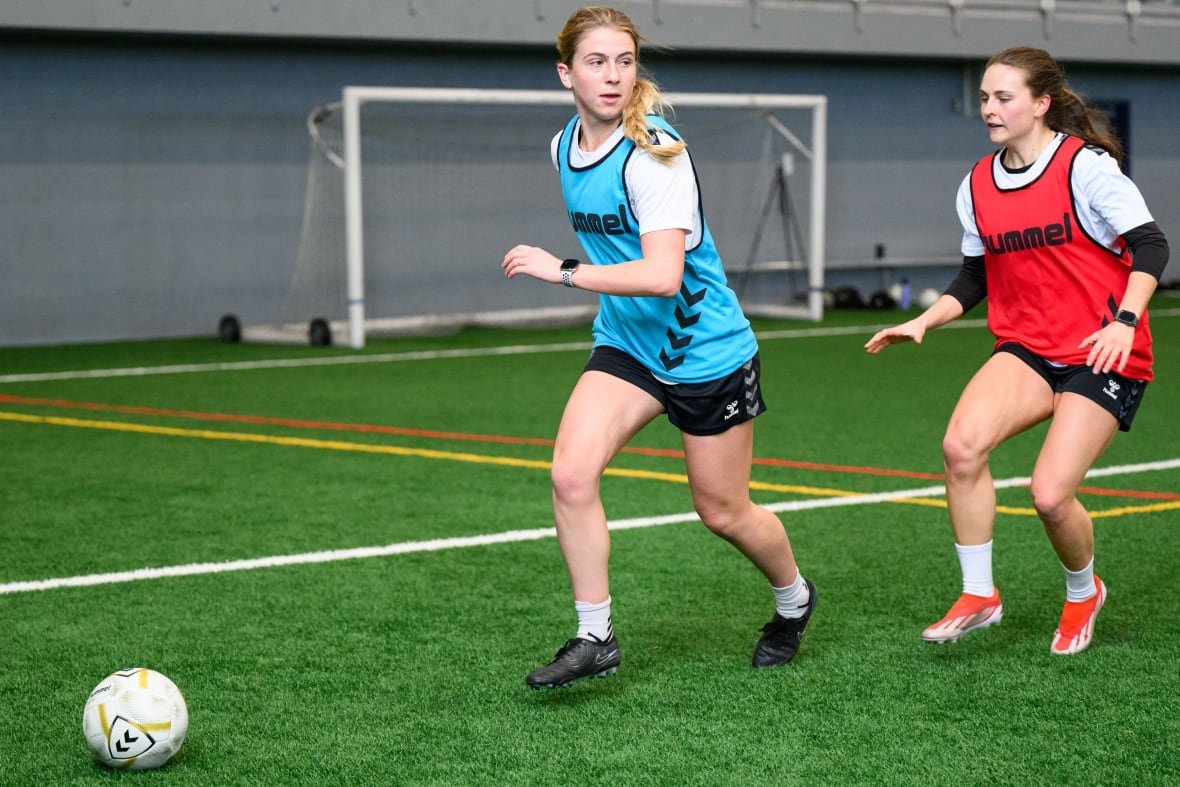 halifax-tides-fc-training-camp Two soccer players pursue the ball on the field.
