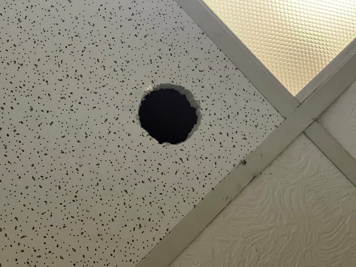 Image of a suspended ceiling with baseball-sized hole cut out taken inside Stitt's now vacant clinic.