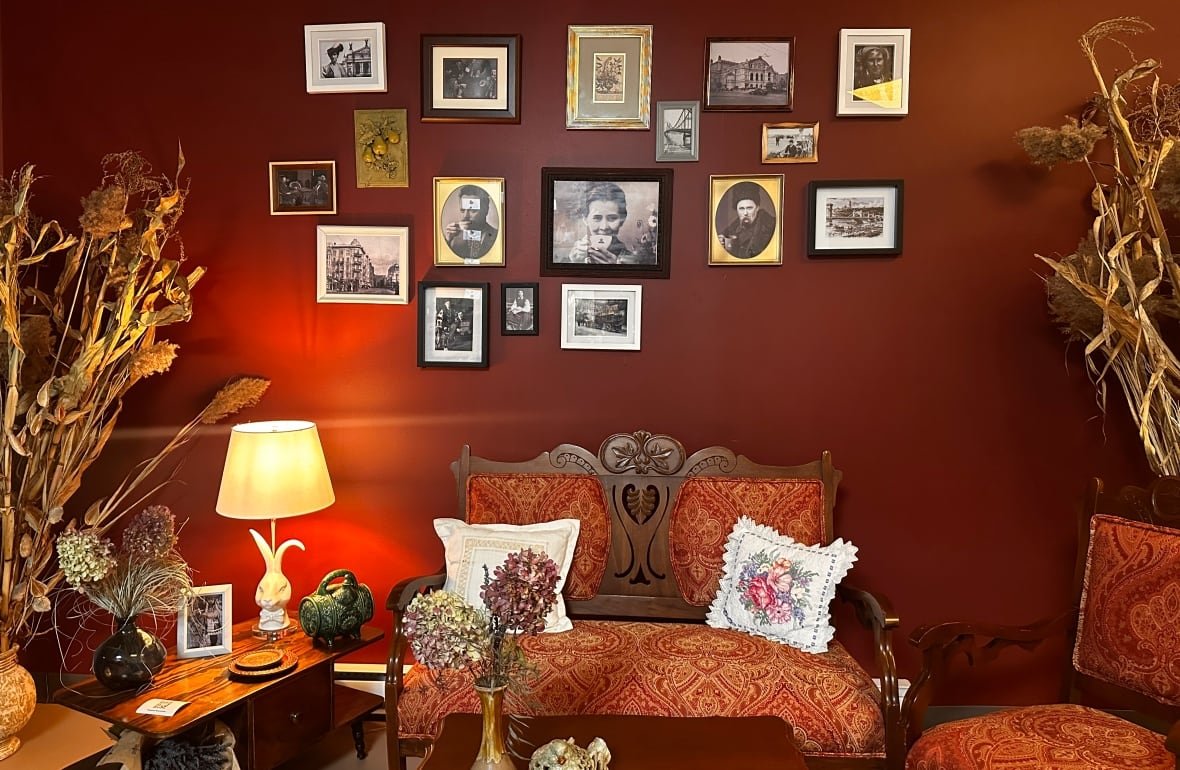 hutsul-coffee-factory Old timey black and white photos on a burgandy wall, with a bench seat underneath.