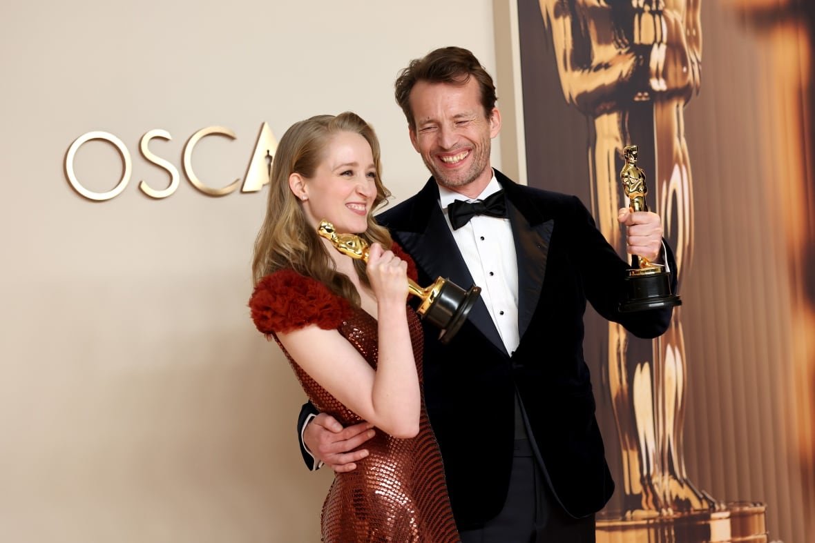 i-m-not-a-robot A man and a woman pose with golden statuettes.
