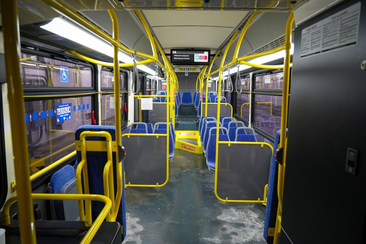 inside-new-flyer-electric-bus-oc-transpo-ottawa-jan-30-2025 Inside of a bus with yellow bars and blue seats