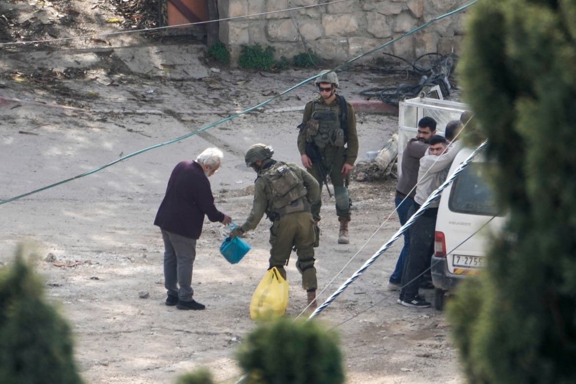 israel-palestinians-3 A soldier checks an elderly man.