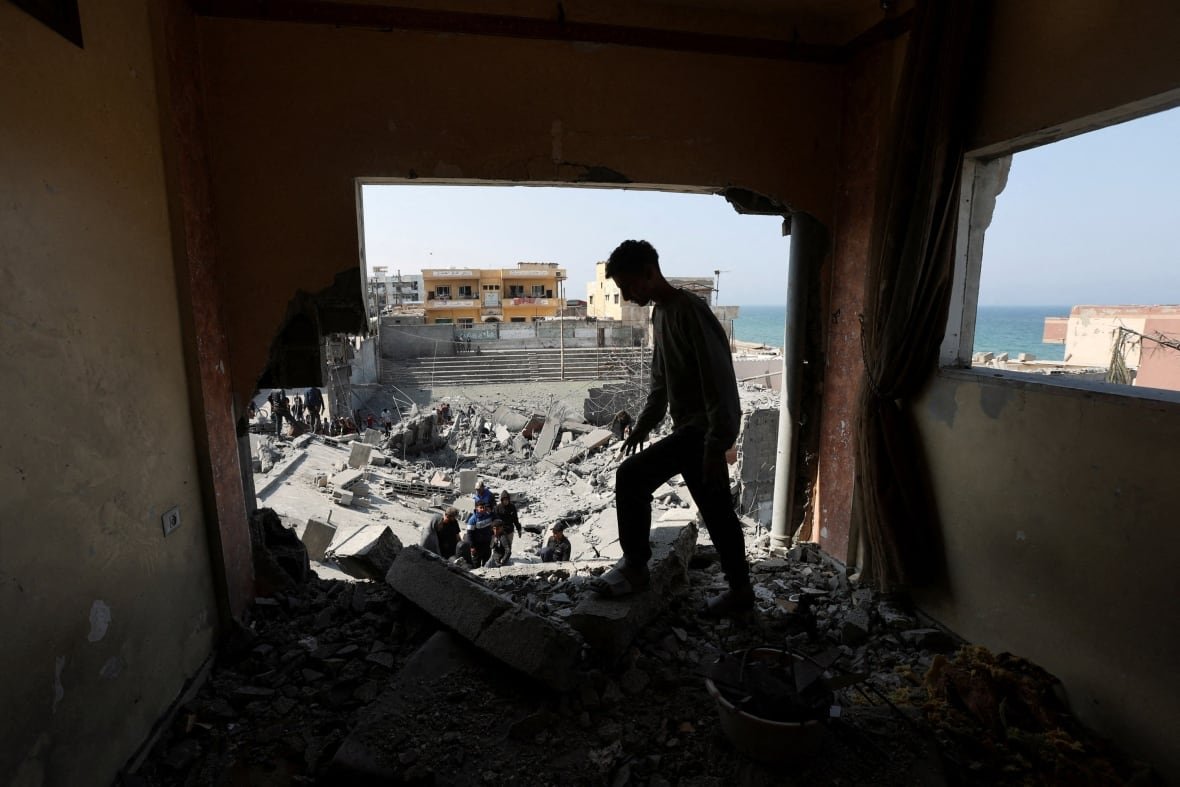 Palestinians inspect the site of an Israeli strike on a residential building, in Deir Al-Balah in the central Gaza Strip