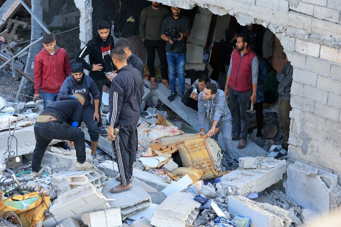 People inspect the sit of a damaged building.