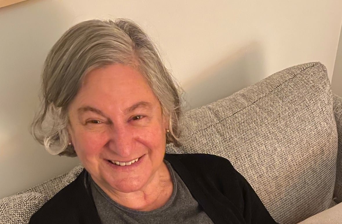 judy-shapiro Close shot photo of a woman with short grey hair sitting on a couch.