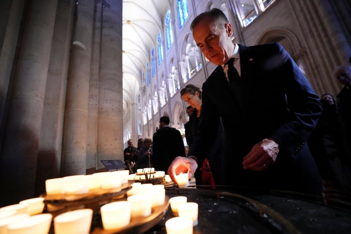 mark-carney-at-notre-dame-cathedral A man lights a candle in Notre-Dame Cathedral in Paris
