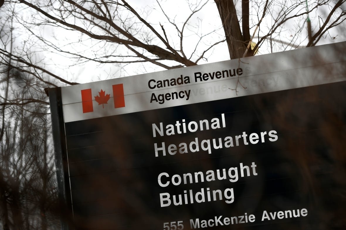 money-monitor-20230427 A sign, slightly obscured by barren branches from a bush, reads "Canada Revenue Agency, National Headquarters."