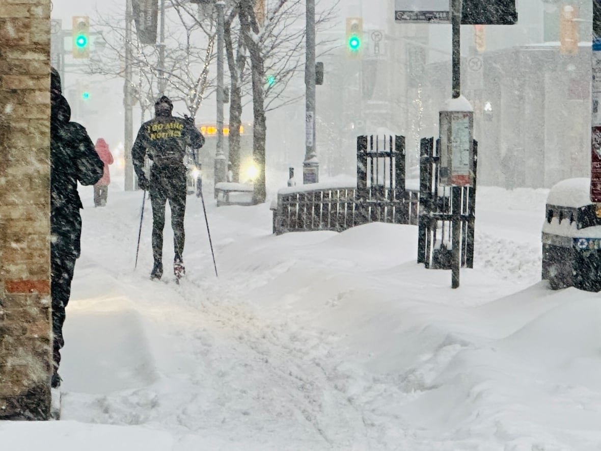 A person skis down a city street.