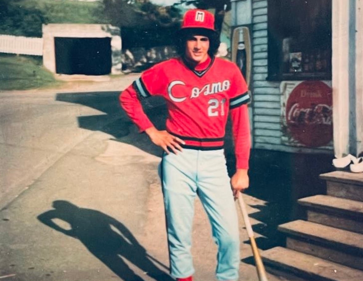 paul-hodgson-1976 A young man wearing a red baseball uniform pictured outside a storefront