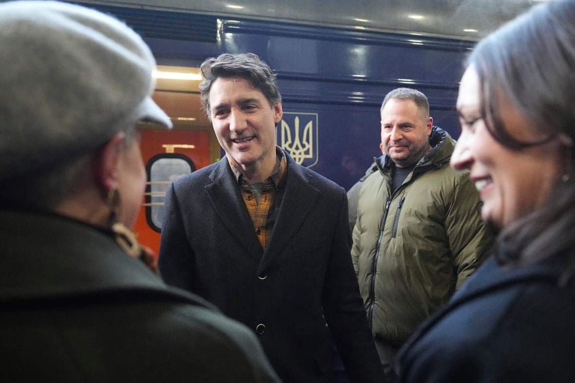 russia-ukraine-war-4 Trudeau stands on a train platform speaking to people.