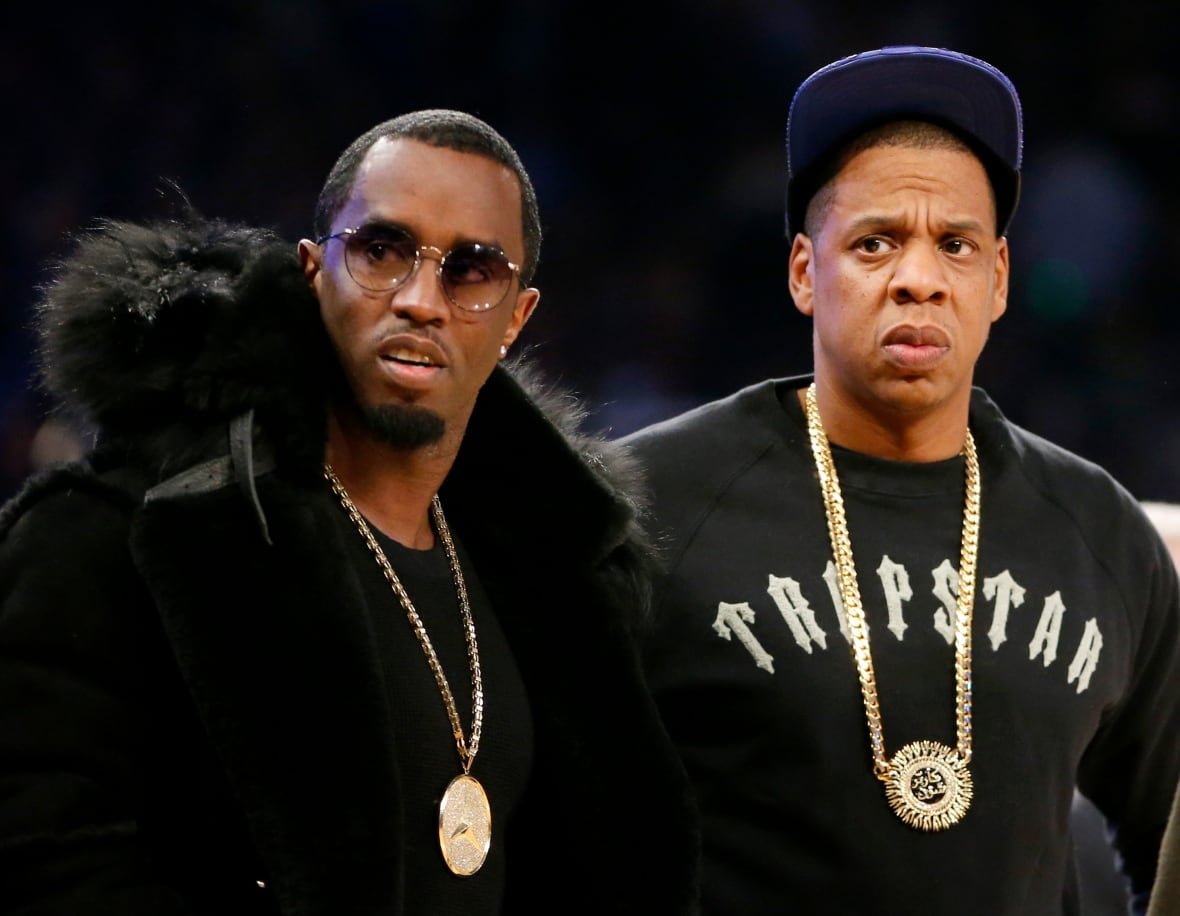 sexual-misconduct-diddy-jay-z Two people are seen standing on the sidelines of a basketball game.