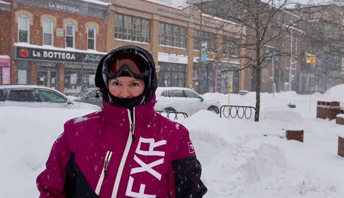 sophie-huneault A woman in a ski suit and goggles stands in Ottawa's ByWard market.