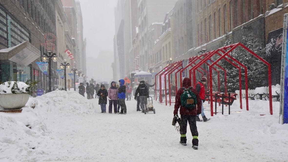 sparks-street-winterlude A snowy street with lots of people on it.