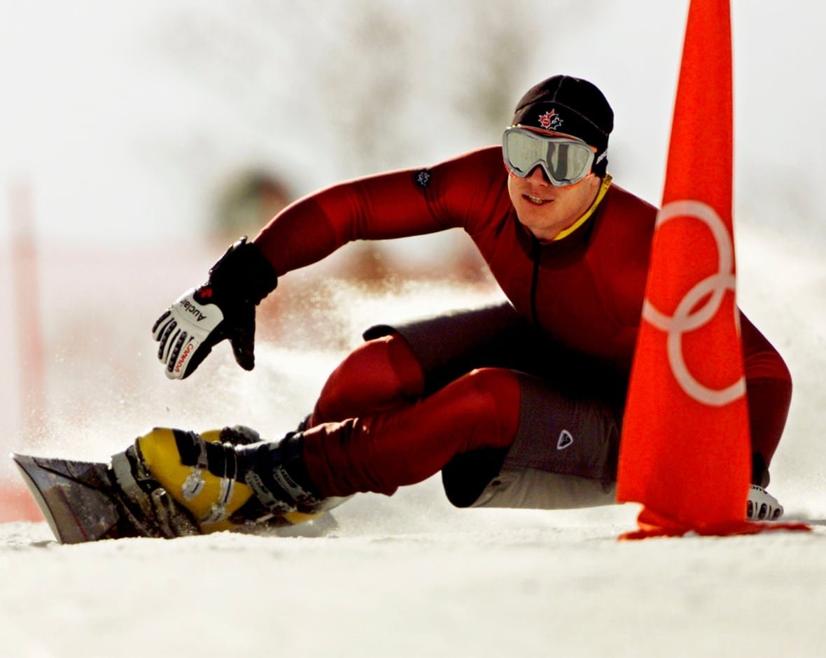 sport-olympics A man takes a tight turn on a snowboard.