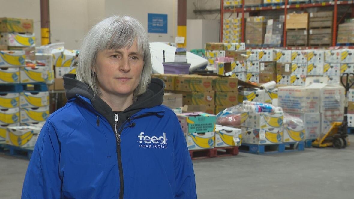 sue-kelleher A woman with a Feed Nova Scotia jacket in a warehouse.
