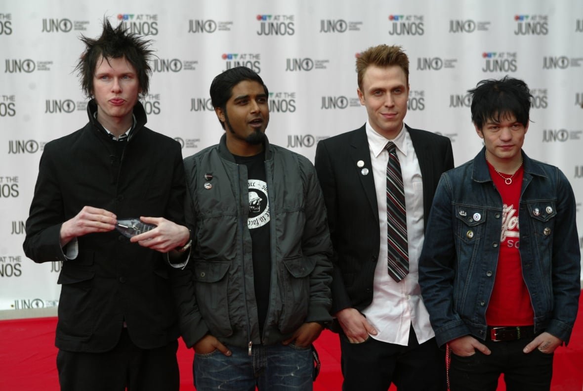 4 people posing on the red carpet.