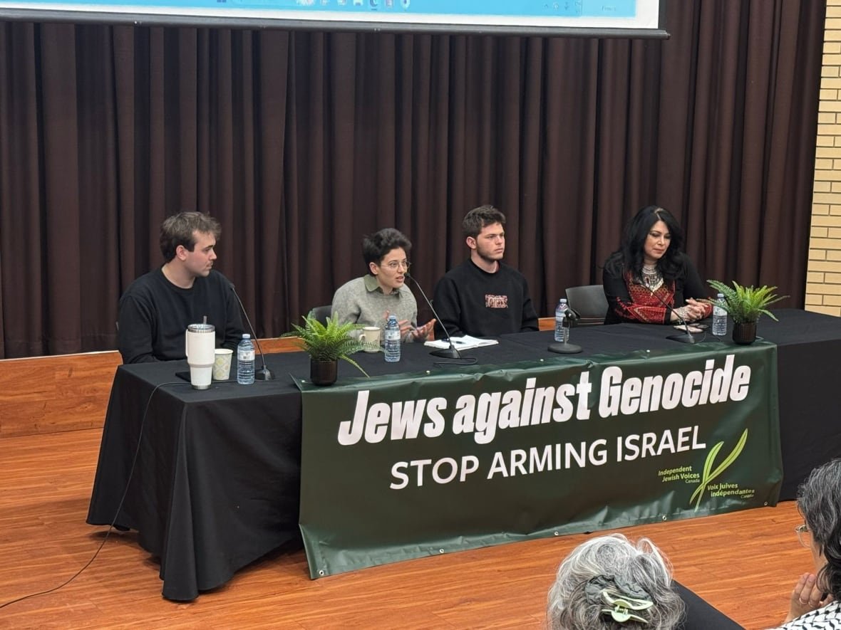tal-mitnick-center-speaks-on-a-panel-during-his-speaking-tour-in-canada-1 four people sit a table with a green table cloth