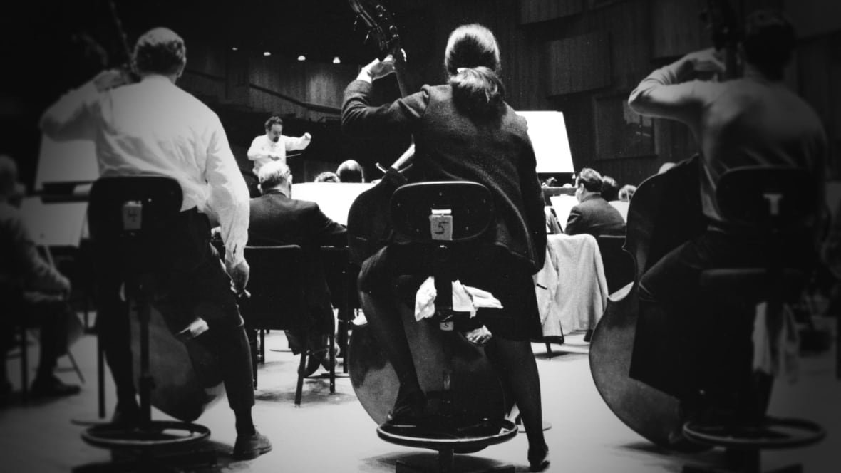Black and white photo of orchestra musicians taken from behind