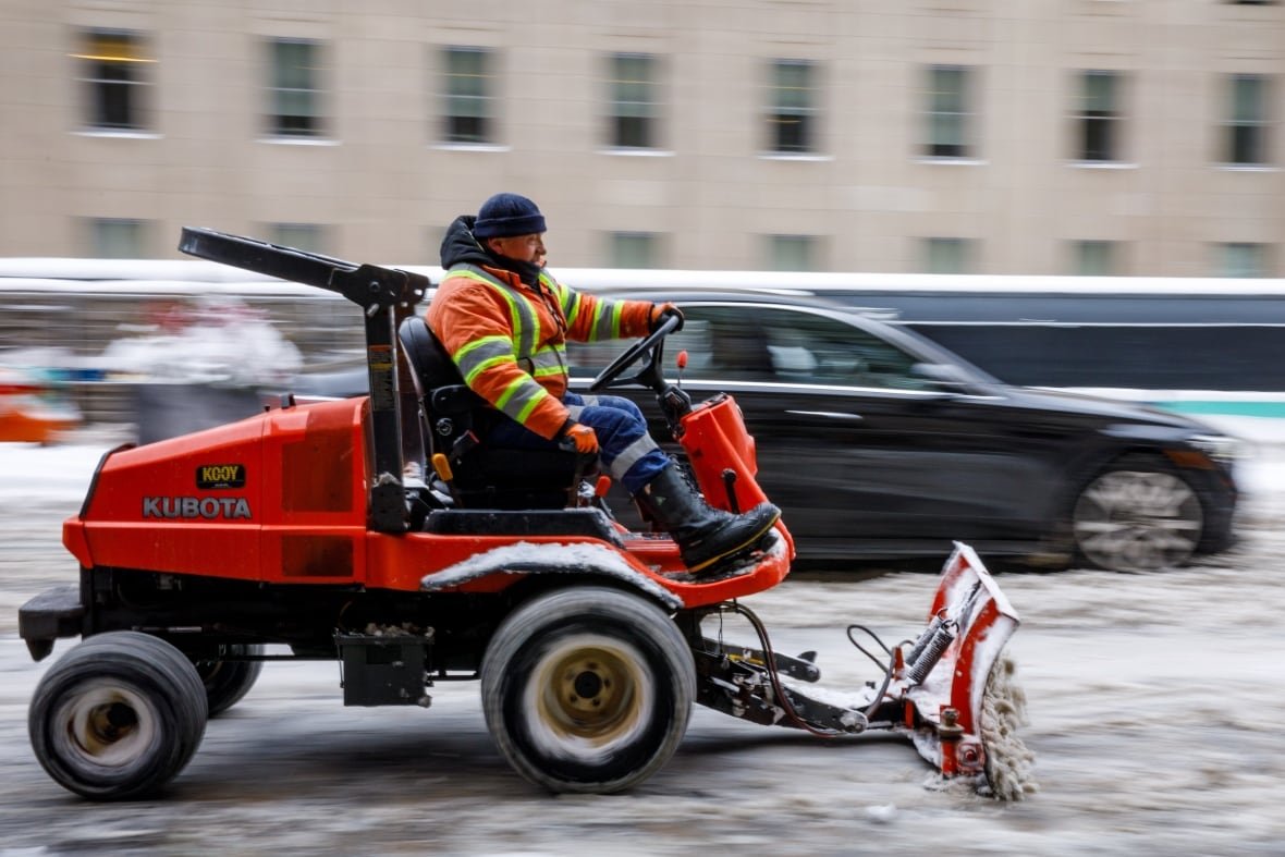 Man riding a snow plough downtown Toronto.