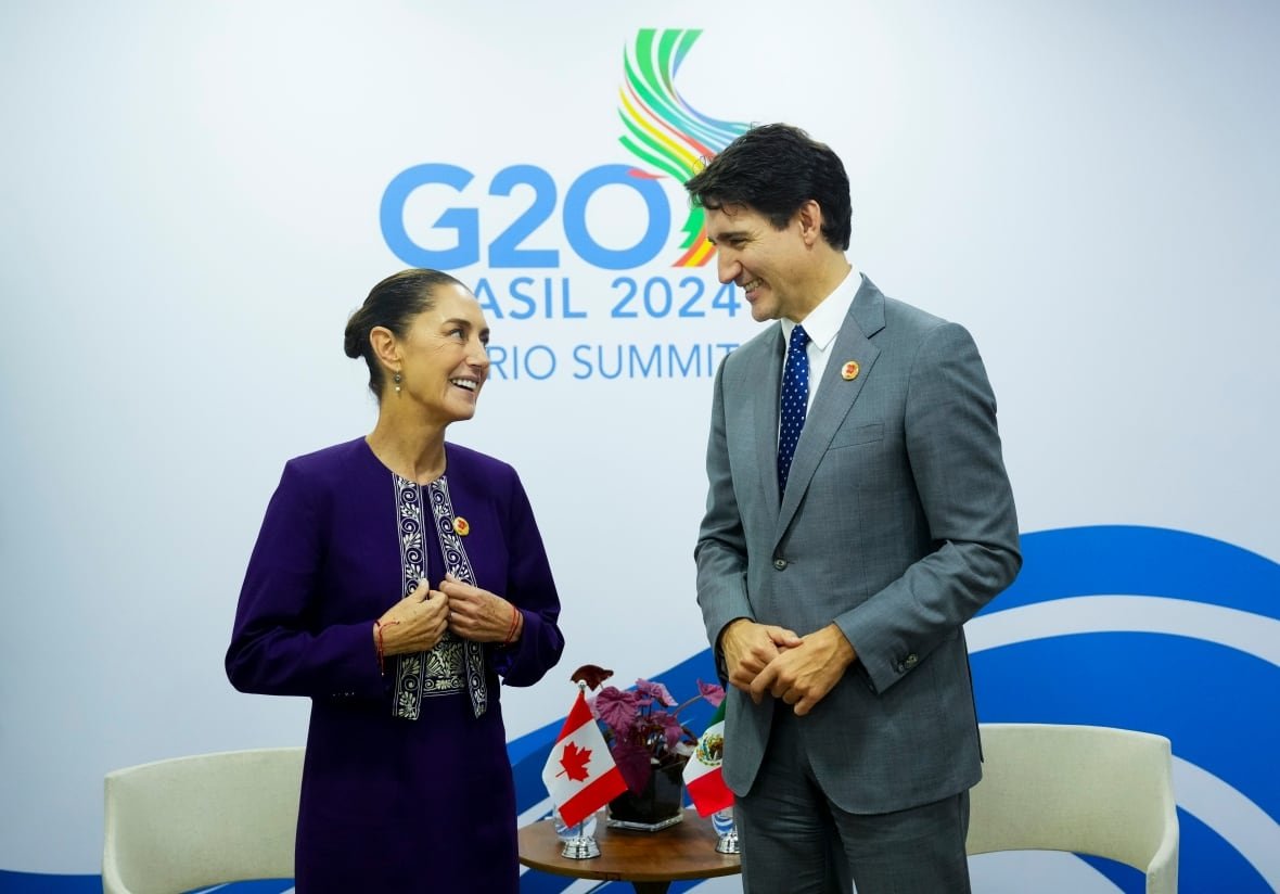 Two people smile at each other while standing.