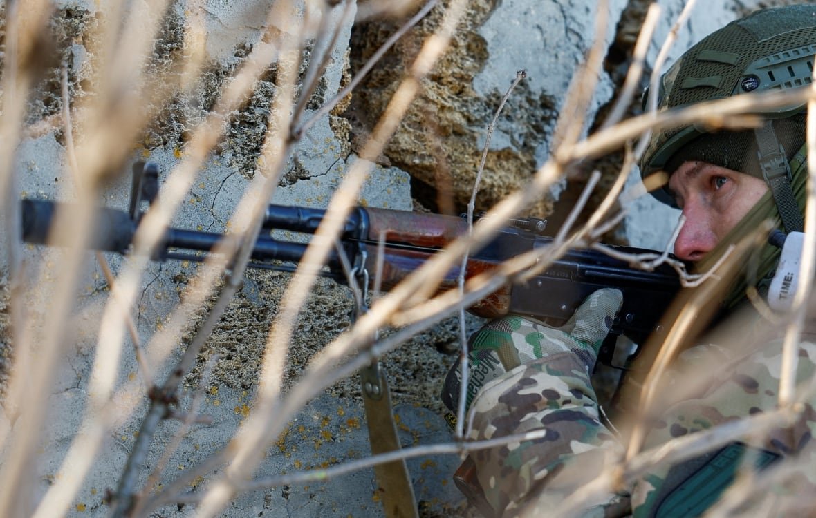 A Ukrainian soldier holding a gun, during a training exercise.