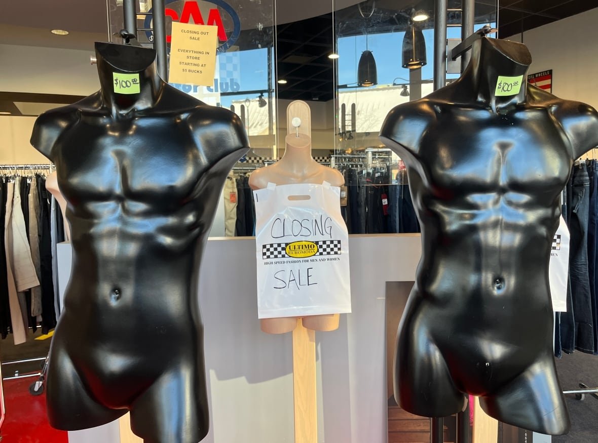 ultimo-euromoda Two headless mannequins with price tags at the entrance of a clothing store.