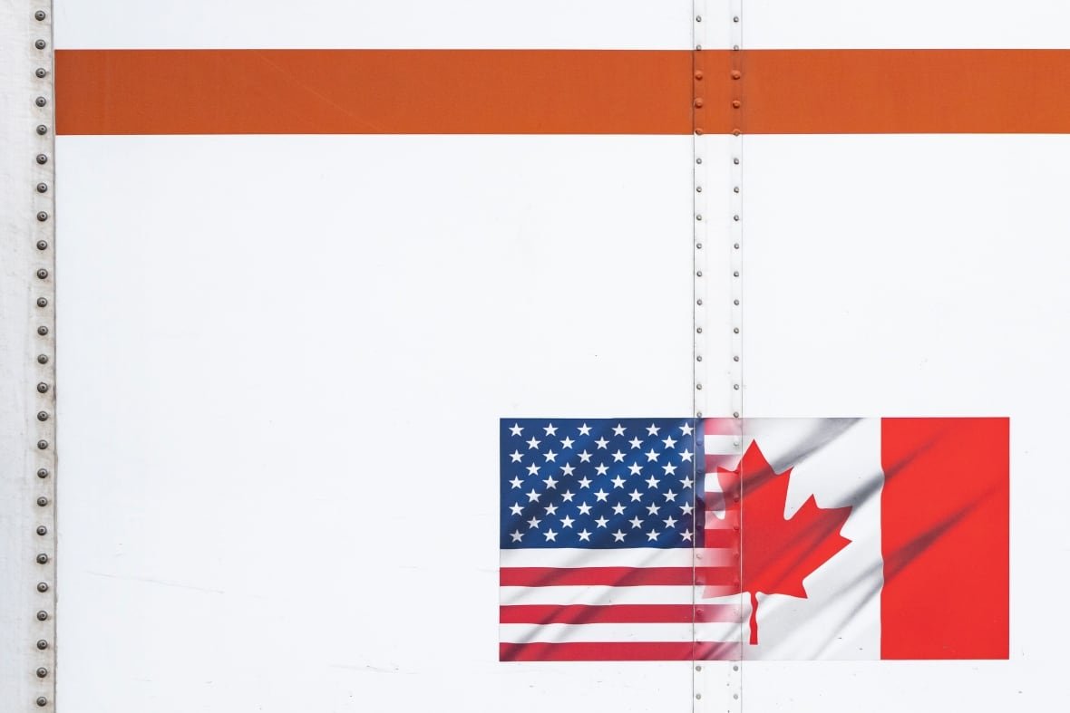us-cda-tariffs-bc-20250304 U.S. and Canada flags are seen on a transport truck trailer at the Pacific Highway Canada-U.S. border crossing in Surrey B.C., on Tuesday, March 4, 2025.