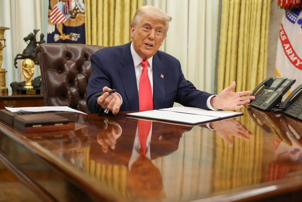 Trump at his desk signing an executive order